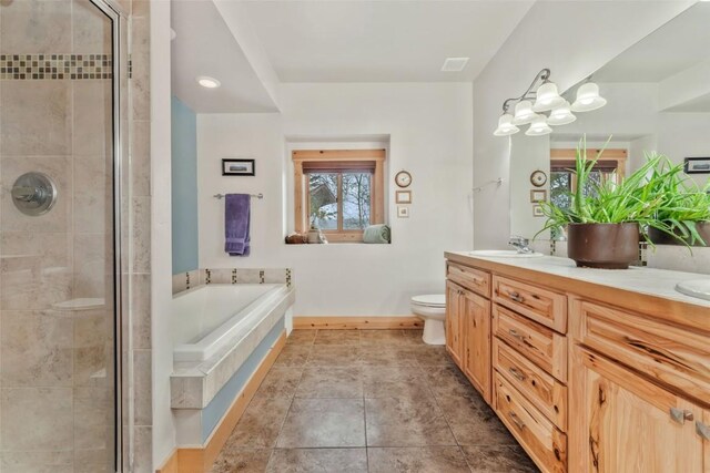 bathroom with double vanity, a sink, a shower stall, a garden tub, and toilet