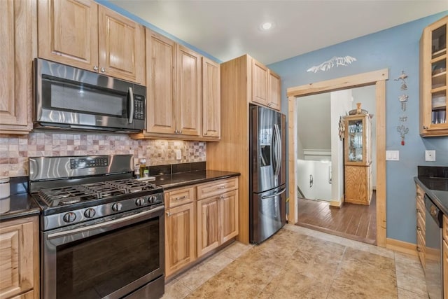 kitchen featuring light brown cabinets, glass insert cabinets, tasteful backsplash, and appliances with stainless steel finishes