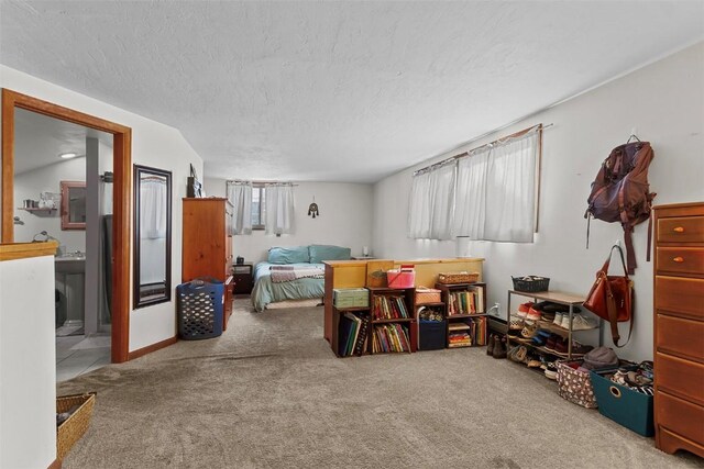 bedroom with carpet, a textured ceiling, ensuite bath, and multiple windows