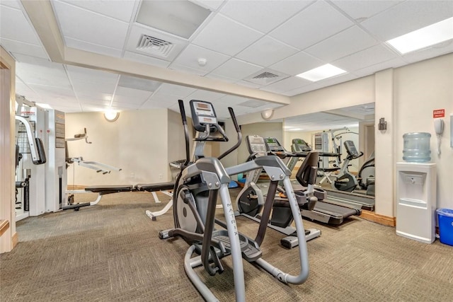 workout area featuring a paneled ceiling, visible vents, and carpet floors