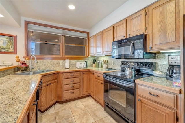 kitchen featuring black appliances, light countertops, backsplash, and a sink