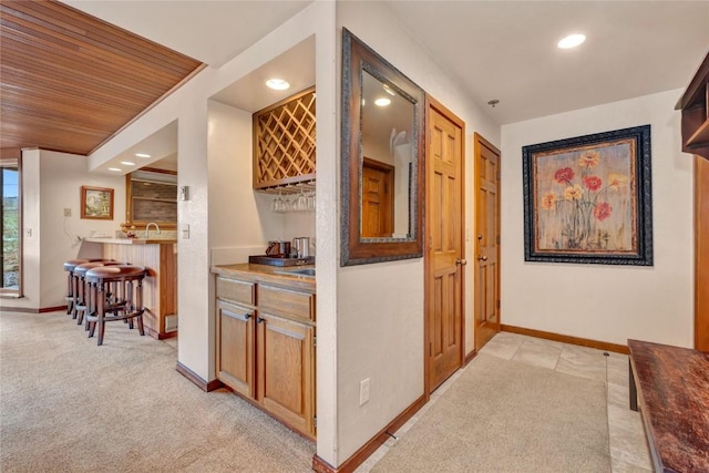 hallway featuring recessed lighting, baseboards, and light carpet