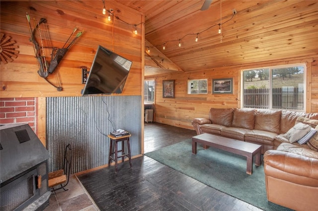 living room with hardwood / wood-style floors, a wood stove, radiator, wooden walls, and vaulted ceiling