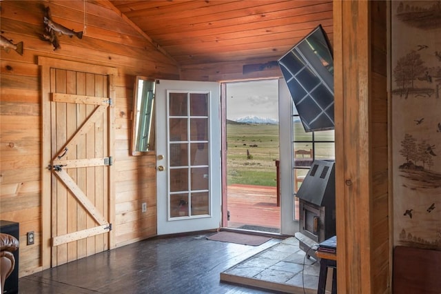 doorway featuring hardwood / wood-style floors, wood ceiling, wooden walls, and vaulted ceiling