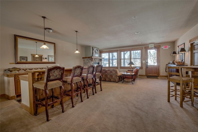 interior space featuring light carpet, a bar, and baseboards