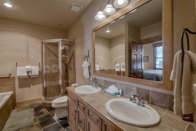 ensuite bathroom with a stall shower, a sink, and visible vents