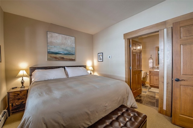 carpeted bedroom with ensuite bath and a baseboard radiator