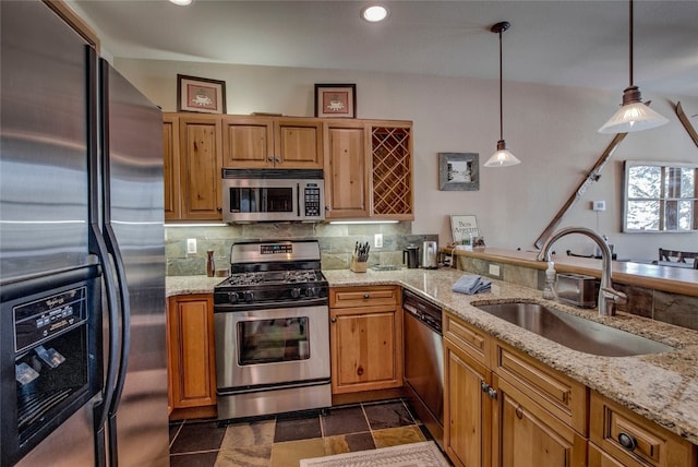 kitchen featuring tasteful backsplash, light stone counters, stainless steel appliances, and a sink