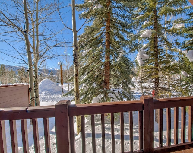 snow covered deck with a mountain view