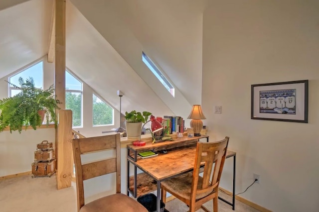 carpeted dining room featuring lofted ceiling with skylight