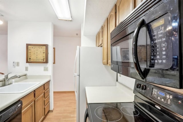 kitchen featuring light wood-type flooring, sink, and black appliances