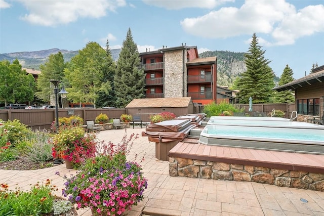 view of swimming pool with a mountain view, a patio, and a hot tub