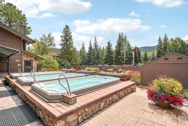 view of pool with a patio area, a mountain view, a fireplace, and a storage unit