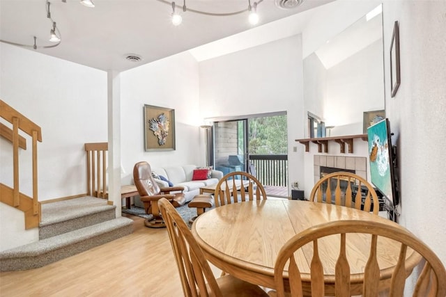 dining area with light wood-type flooring and a fireplace