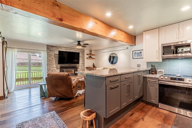 kitchen with gray cabinetry, decorative backsplash, white cabinetry, and stainless steel appliances