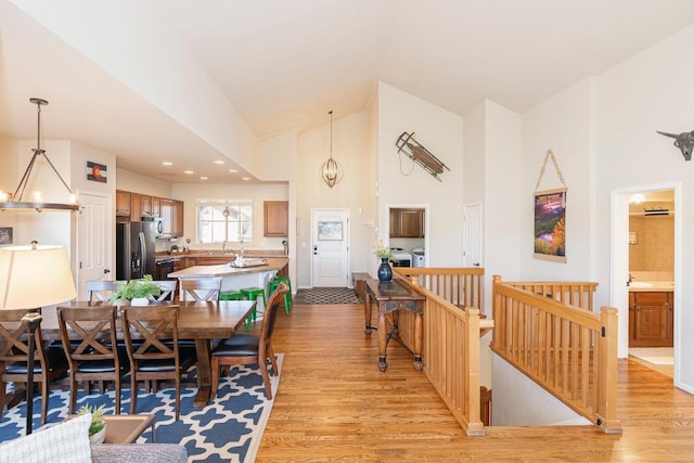 dining area featuring light hardwood / wood-style flooring, lofted ceiling, and an inviting chandelier