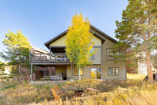 back of property with a patio area, a fire pit, and a deck