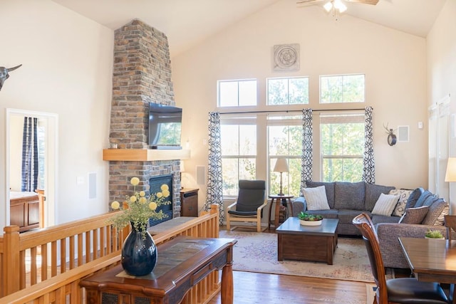 living room featuring a fireplace, dark hardwood / wood-style flooring, high vaulted ceiling, and ceiling fan