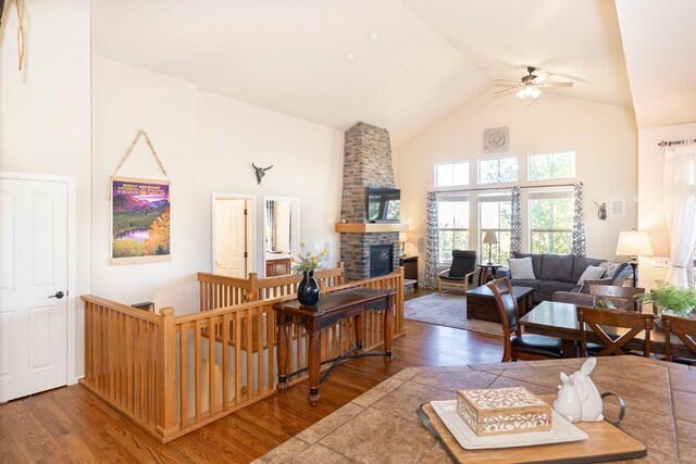 living room with a fireplace, hardwood / wood-style flooring, high vaulted ceiling, and ceiling fan