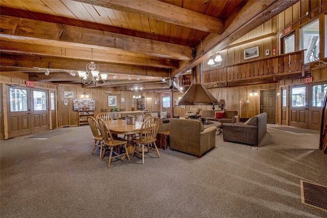 carpeted dining area featuring track lighting, wood ceiling, wooden walls, beam ceiling, and a notable chandelier