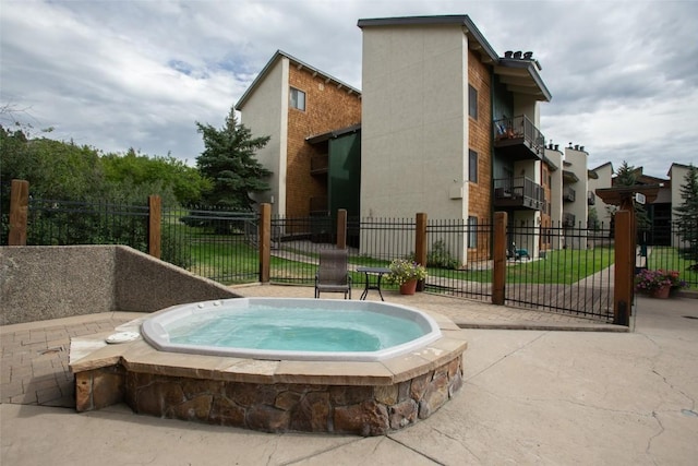 view of swimming pool featuring an in ground hot tub and fence