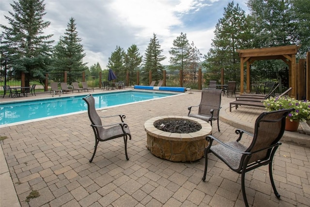 pool featuring an outdoor fire pit, a patio, and fence