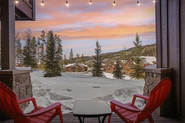 view of snow covered back of property