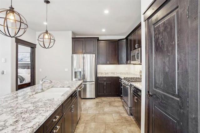 kitchen featuring pendant lighting, sink, appliances with stainless steel finishes, dark brown cabinets, and light stone counters