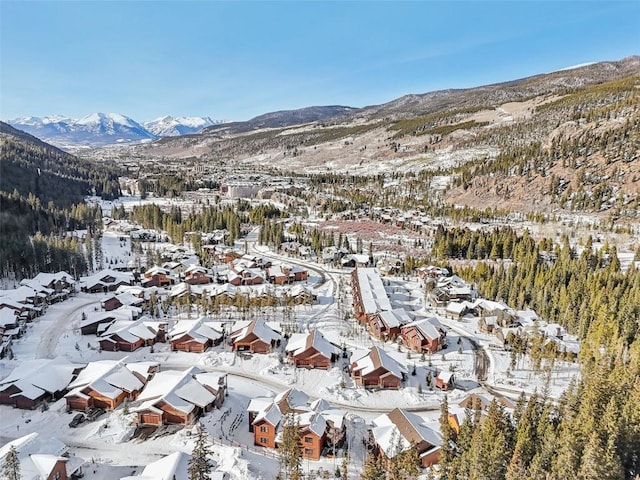 snowy aerial view featuring a mountain view and a residential view