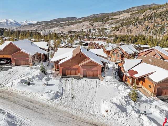 snowy aerial view with a residential view and a mountain view