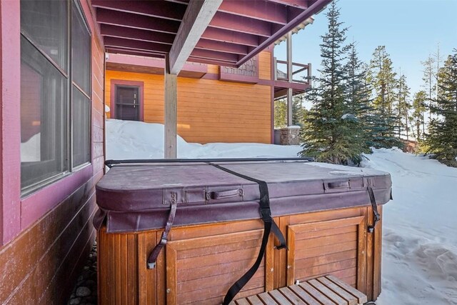 snow covered patio featuring a hot tub