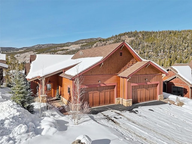 view of front of house featuring a mountain view, a forest view, and a garage