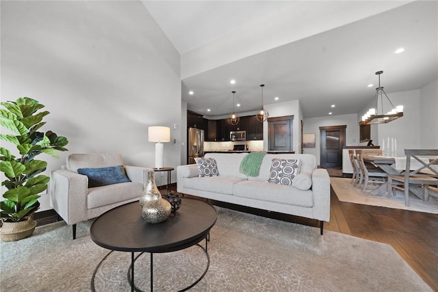 living room featuring a notable chandelier, recessed lighting, and dark wood-style flooring