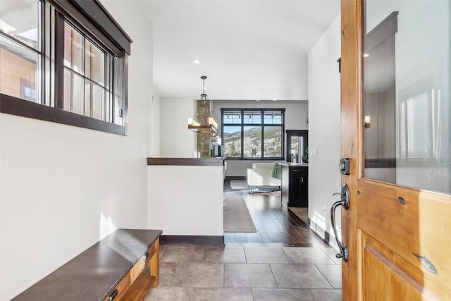 foyer with baseboards and a notable chandelier