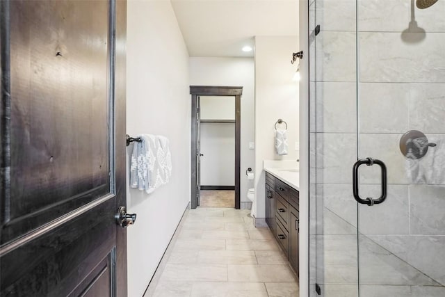 bathroom with tile patterned floors, vanity, toilet, and a shower with shower door