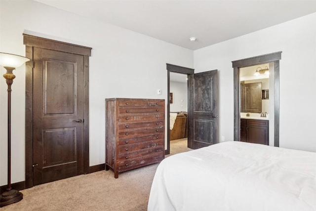 bedroom with a sink, connected bathroom, and light colored carpet