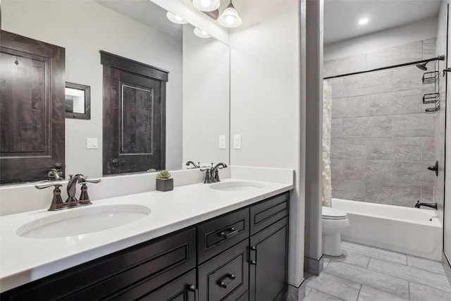 full bathroom with vanity, tiled shower / bath combo, and toilet