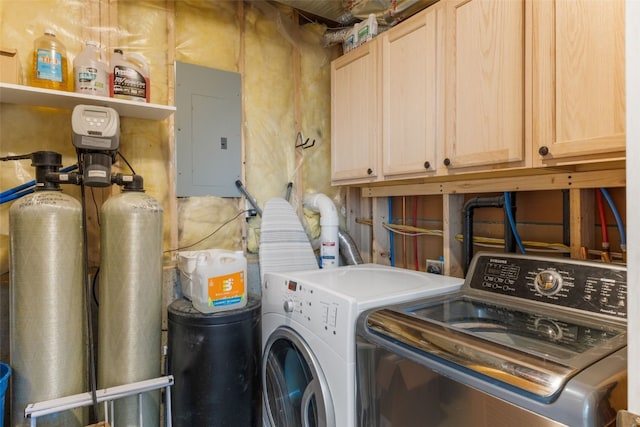 laundry area with electric panel, separate washer and dryer, and cabinets