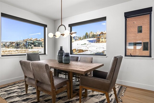 dining area with hardwood / wood-style flooring and an inviting chandelier