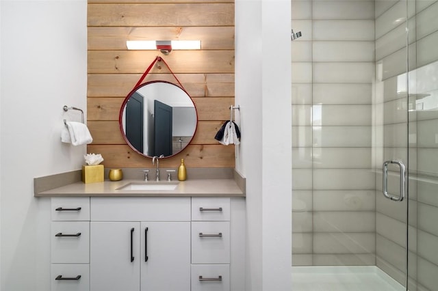 bathroom with vanity, wooden walls, and a shower with shower door