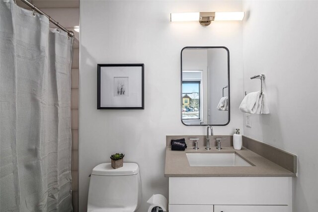 bathroom featuring toilet, a shower with curtain, and vanity