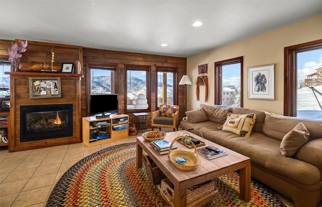 tiled living room featuring a healthy amount of sunlight and a large fireplace