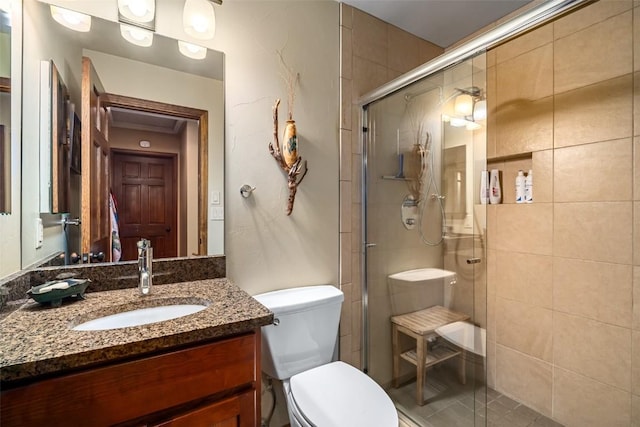 bathroom with vanity, a shower with shower door, and toilet