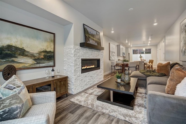 living room featuring a stone fireplace and hardwood / wood-style floors