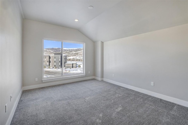 carpeted spare room with vaulted ceiling and a mountain view