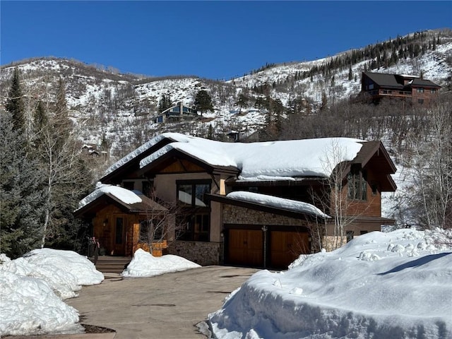 view of front of home featuring stone siding and a mountain view