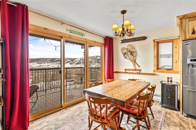 dining room featuring a chandelier, a mountain view, light wood-style floors, and a baseboard radiator