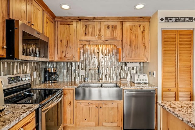 kitchen featuring tasteful backsplash, recessed lighting, stainless steel appliances, and light stone countertops