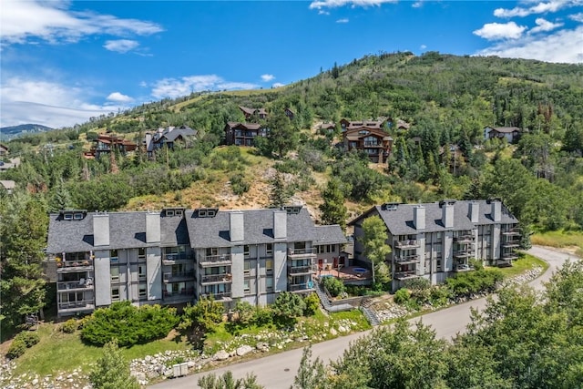 birds eye view of property with a mountain view and a wooded view