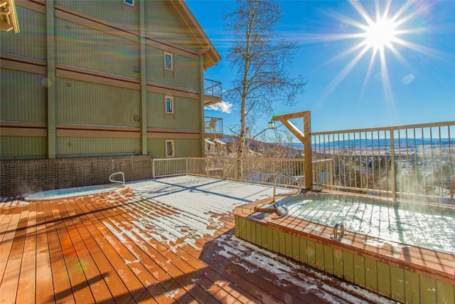 wooden terrace featuring hot tub deck surround